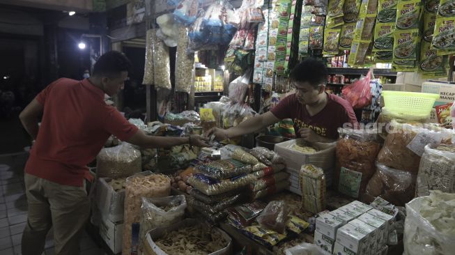 Pedagang melayani pembeli di Pasar Tebet Timur, Jakarta, Kamis (10/6/2021). [Suara.com/Angga Budhiyanto]