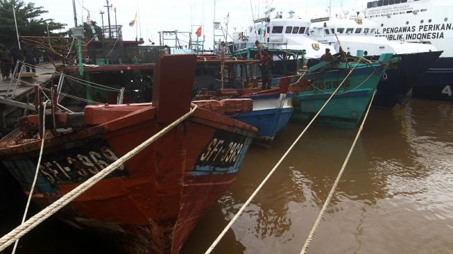 Sejumlah petugas Kapal Pengawas Kementerian Kelautan dan Perikanan (KKP) bersiaga di kapal ikan ilegal hasil tangkapan di Stasiun Pengawasan Sumber Daya Kelautan dan Perikanan (PSDKP) Pontianak di Sungai Rengas, Kabupaten Kubu Raya, Kalimantan Barat, Kamis (10/6/2021). ANTARA FOTO/Jessica Helena Wuysang