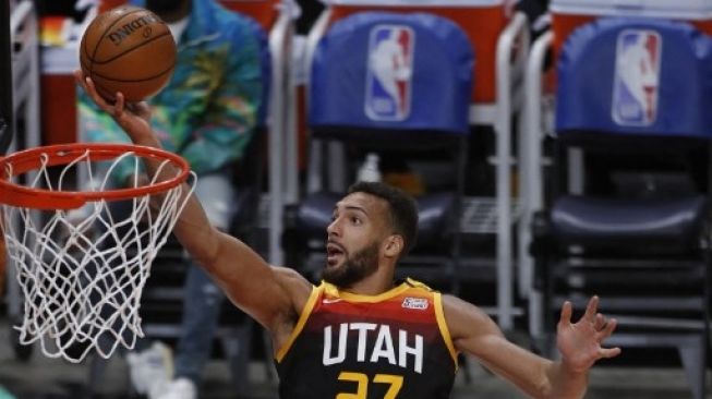 Pemain center Utah Jazz Rudy Gobert memasukan bola saat pertandingan NBA di Salt Lake City, Utah. GEORGE FREY / AFP