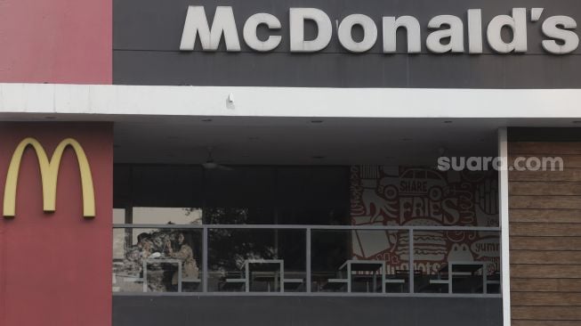 Pengunjung menikmati hidangan di gerai restoran cepat saji McDonald's Raden Saleh, Jakarta, Kamis (10/6/2021). [Suara.com/Angga Budhiyanto]