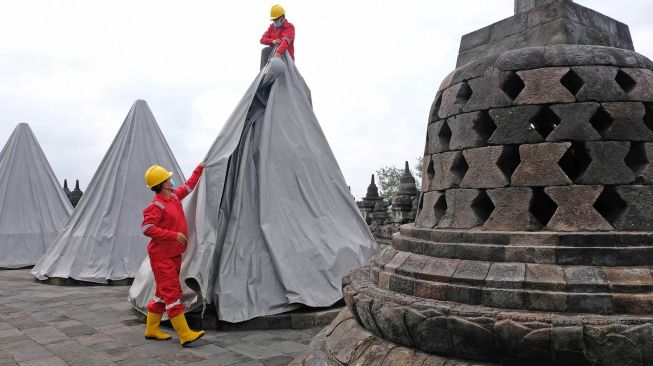 Petugas Balai Konservasi Borobudur (BKB) membuka terpaulin penutup stupa candi Borobudur Magelang, Jawa Tengah, Kamis (10/6/2021). ANTARA FOTO/Anis Efizudin