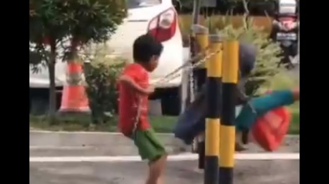 Bikin Terenyuh! Anak Jalanan Main Ayunan di Pembatas Jalan, 'Bahagia itu Sederhana'