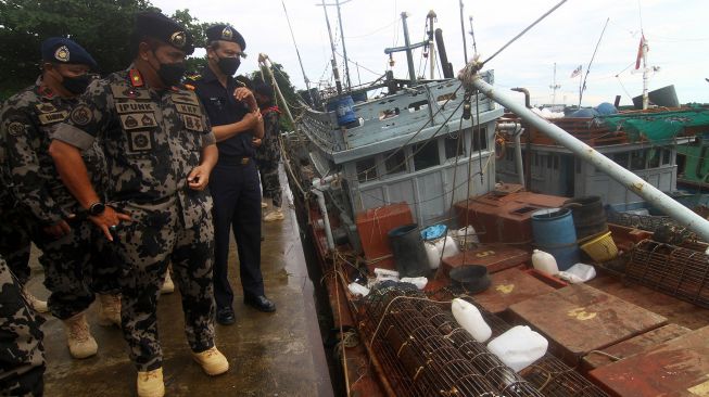 Direktur Pemantauan dan Operasi KKP Armada Pung Nugroho Saksono (kedua kiri) meninjau kapal ikan ilegal hasil tangkapan di Stasiun Pengawasan Sumber Daya Kelautan dan Perikanan (PSDKP) Pontianak di Sungai Rengas, Kabupaten Kubu Raya, Kalimantan Barat, Kamis (10/6/2021).  ANTARA FOTO/Jessica Helena Wuysang