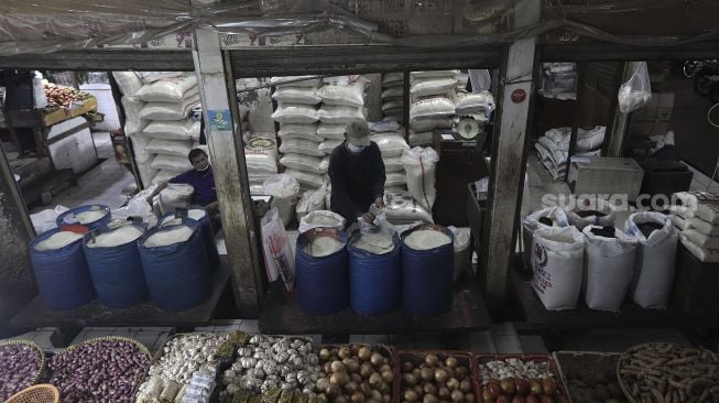 Pedagang mengemas beras di Pasar Tebet Timur, Jakarta, Kamis (10/6/2021). [Suara.com/Angga Budhiyanto]