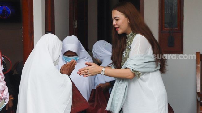 Ratu Rizky Nabila menyalami tamu yang hadir saat Aqiqah putranya yang bernama Jewanio Rizky Abbaz  di Kebun Jeruk, Jakarta Barat, Jumat (11/6/2021). [Suara.com/Alfian Winanto]