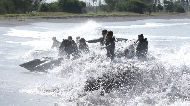 Prajurit Batalyon Intai Amfibi (Yontaifib) Korps Marinir TNI AL dan United States Marines Corps Reconnaissance Unit menerjang gelombang dalam Latihan Bersama Reconex 21-II di Pusat Latihan Pertempuran Marinir (Puslatpurmar) 7 Lampon, Banyuwangi, Jawa Timur, Jumat (11/6/2021). ANTARA FOTO/Budi Candra Setya
