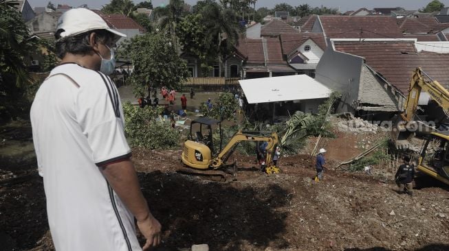 Warga melihat rumah yang hancur tertimpa tanah longsor di Perumahan Nerada Estate Ciputat, Tangerang Selatan, Banten, Sabtu (12/6/2021). [Suara.com/Angga Budhiyanto]