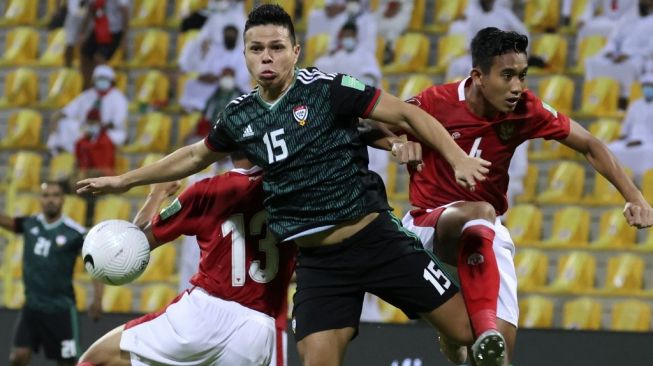 Gelandang serang Timnas Uni Emirat Arab, Fabio Lima (tengah) berduel udara dengan bek Timnas Indonesia, Rizky Ridho Ramadhani (kanan) pada laga Kualifikasi Piala Dunia 2022 Zona Asia di Zabeel Stadium,Dubai, UEA, Sabtu (12/6/2021) dini hari WIB. [Karim SAHIB / AFP]