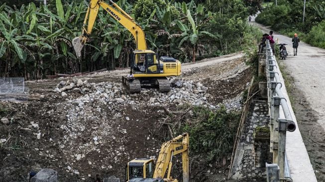 Sejumlah warga melihat proses pekerjaan normalisasi sungai di Arsopura, Kabupaten Keerom, Papua, Sabtu (12/06/2021). [ANTARA FOTO/Indrayadi TH]