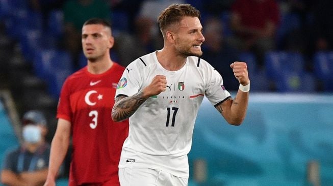 Penyerang Timnas Italia, Ciro Immobile (kanan) merayakan golnya ke gawang Turki dalam laga Grup A Euro 2020 di Stadio Olimpico, Roma, Sabtu (12/6/2021) dini hari WIB. [Filippo MONTEFORTE / POOL / AFP]