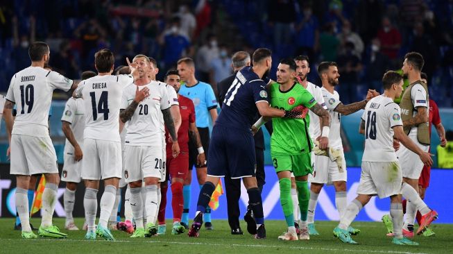 Para pemain timnas Italia merayakan kemenangan 3-0 mereka atas Turki sembari bersalaman dengan pemain lawan, usai laga perdana Euro 2020 di Grup A yang berlangsung di Stadion Olimpico, Roma, Jumat (11/6/2021) malam atau Sabtu dini hari WIB. [Filippo MONTEFORTE / AFP / POOL]