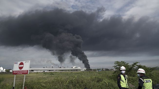 Asap hitam terlihat mengepul di tanki penyimpanan benzene yang terbakar di Area Kilang Pertamina RU IV Cilacap, Jateng, Sabtu (12/6/2021). [ANTARA FOTO/Idhad Zakaria]