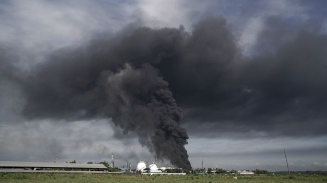 Asap hitam terlihat mengepul di tanki penyimpanan benzene yang terbakar di Area Kilang Pertamina RU IV Cilacap, Jateng, Sabtu (12/6/2021). [ANTARA FOTO/Idhad Zakaria]