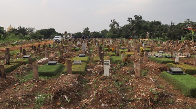 Kondisi makam di area khusus Covid-19 TPU Srengseng Sawah, Jakarta Sekatan, Minggu (13/6/2021). [Suara.com/Alfian Winanto]