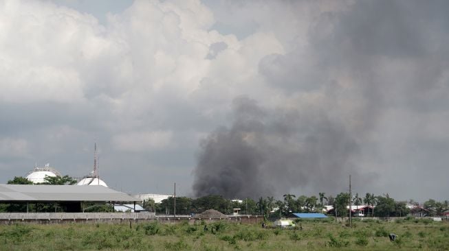 Asap hitam terlihat terlihat mulai menghilang sesaat sebelum api berhasil dipadamkan, di Kilang Pertamina RU IV Cilacap, Jawa Tengah, Minggu (13/6/2021).  ANTARA FOTO/Idhad Zakaria