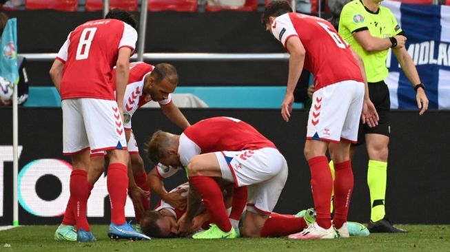 Le milieu de terrain de l'équipe nationale du Danemark Christian Eriksen (en bas) s'est effondré au milieu du terrain lors du match du groupe B de l'Euro 2020 contre la Finlande, samedi (13/6/2021) soir WIB. [Jonathan NACKSTRAND / AFP / POOL]