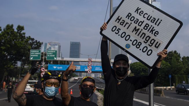 Sejumlah pesepeda dari Bike to Work Indonesia dan mitra koalisinya menunjukkan rambu bertuliskan �kecuali road bike� yang telah dicopot di sekitar Jalan Layang Non Tol (JLNT) Casablanca, Jakarta, Minggu (13/6/2021).  ANTARA FOTO/Sigid Kurniawan
