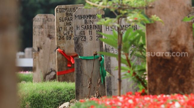 Makam - makam di area khusus Covid-19 yang diberi penanda kain di TPU Srengseng Sawah, Jakarta Sekatan, Minggu (13/6/2021). [Suara.com/Alfian Winanto]