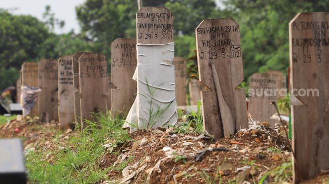 Makam - makam di area khusus Covid-19 yang diberi penanda kain di TPU Srengseng Sawah, Jakarta Sekatan, Minggu (13/6/2021). [Suara.com/Alfian Winanto]