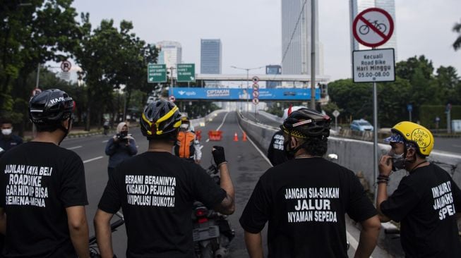 Sejumlah pesepeda dari Bike to Work Indonesia dan mitra koalisinya menunggu pencopotan rambu bertuliskan �kecuali road bike� di sekitar Jalan Layang Non Tol (JLNT) Casablanca, Jakarta, Minggu (13/6/2021).  ANTARA FOTO/Sigid Kurniawan