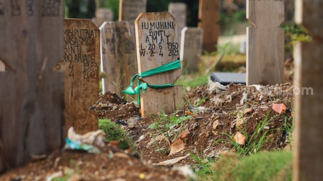 Makam - makam di area khusus Covid-19 yang diberi penanda kain di TPU Srengseng Sawah, Jakarta Sekatan, Minggu (13/6/2021). [Suara.com/Alfian Winanto]