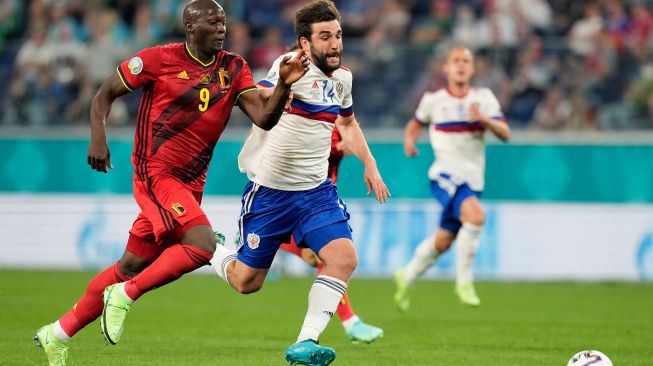 Pemain depan Belgia Romelu Lukaku berebut bola dengan bek Rusia Georgiy Dzhikiya selama pertandingan sepak bola Grup B EURO 2020 antara Belgia melawan Rusia di Stadion Saint Petersburg di Saint Petersburg, Rusia, Minggu (13/6). dinih hari WIB. Dmitri Lovetsky / POOL / AFP

