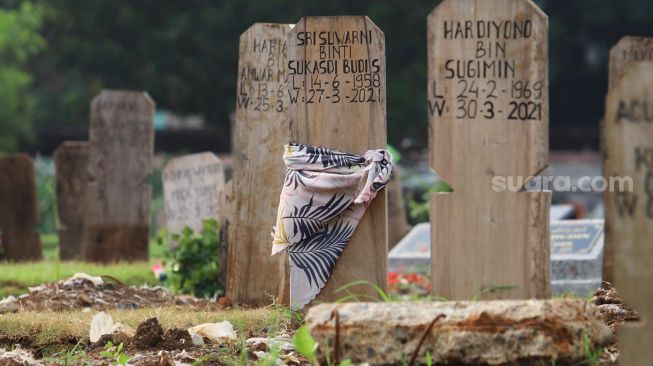 Makam - makam di area khusus Covid-19 yang diberi penanda kain di TPU Srengseng Sawah, Jakarta Sekatan, Minggu (13/6/2021). [Suara.com/Alfian Winanto]