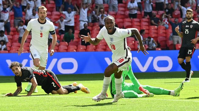 Pemain depan Inggris Raheem Sterling merayakan usai mencetak gol pertama timnya selama pertandingan sepak bola Grup D EURO 2020 antara Inggris melawan Kroasia di Wembley, London, Minggu (13/6/2021) malam WIB.
Glyn KIRK / POOL / AFP