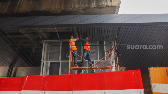 Sejumlah pekerja merampungkan pengerjaan proyek penataan kawasan Stasiun Tebet di Jakarta Selatan, Senin (14/6/2021). [Suara.com/Alfian Winanto]