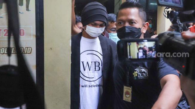 Penyanyi Erdian Aji Prihartanto alias Anji saat dibawa ke ruang kesehatan untuk dilakukan pemeriksaan setelah ditangkap karena kasus narkoba di Polres Metro Jakarta Barat, Senin (14/6/2021). [Suara.com/Alfian Winanto]