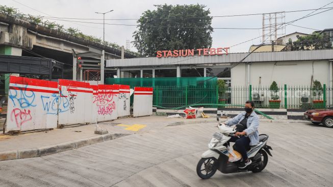 Warga melintas di sekitar kawasan Stasiun Tebet  yang sedang dilakukan proyek penataan di Jakarta Selatan, Senin (14/6/2021). [Suara.com/Alfian Winanto]