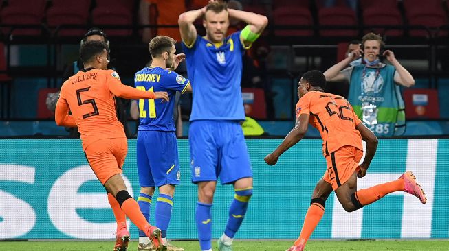 Bek Belanda Denzel Dumfries merayakan setelah mencetak gol ketiga selama pertandingan sepak bola Grup C EURO 2020 antara Belanda melawan Ukraina di Johan Cruyff Arena di Amsterdam, Belanda, Senin (14/6) dini hari WIB.  JOHN THYS / POOL / AFP