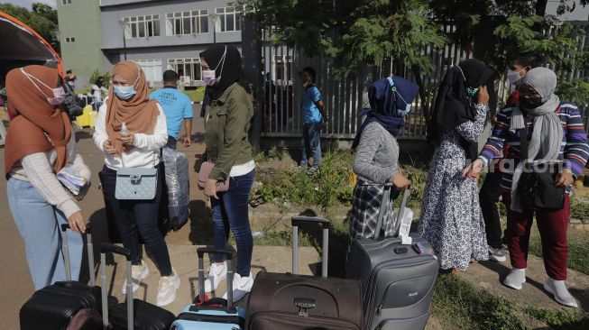 Sejumlah Pekerja Migran Indonesia (PMI) menunggu dijemput pihak keluarga usai menjalani isolasi di Rumah Sakit Darurat COVID-19 (RSDC) Wisma Atlet Pademangan, Jakarta, Selasa (15/6/2021). [Suara.com/Angga Budhiyanto]