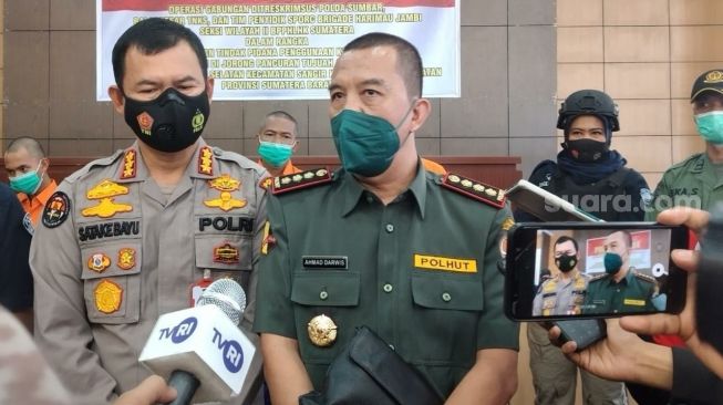 Kabid Wilayah II Taman Nasional Kerinci Seblat (TNKS) Sumbar, Ahmad Darwis bersama Kabid Humas Polda Sumbar saat diwawancarai wartawan di Polda Sumbar. (Suara.com/B. Rahmat)