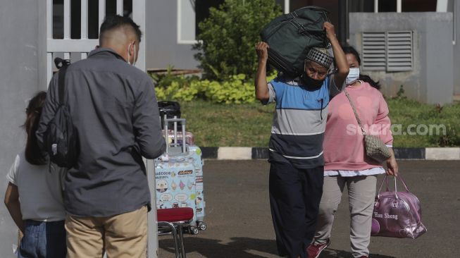 Pekerja Migran Indonesia (PMI) berjalan meninggalkan ruangan usai menjalani isolasi di Rumah Sakit Darurat COVID-19 (RSDC) Wisma Atlet Pademangan, Jakarta, Selasa (15/6/2021). [Suara.com/Angga Budhiyanto]