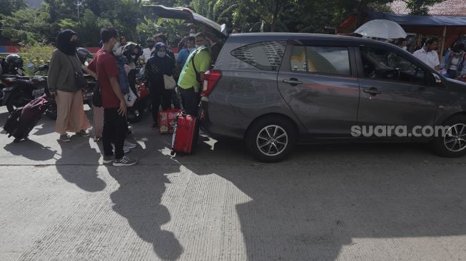 Pekerja Migran Indonesia (PMI) menaikkan barang bawaan ke dalam mobil usai menjalani isolasi di Rumah Sakit Darurat COVID-19 (RSDC) Wisma Atlet Pademangan, Jakarta, Selasa (15/6/2021). [Suara.com/Angga Budhiyanto]