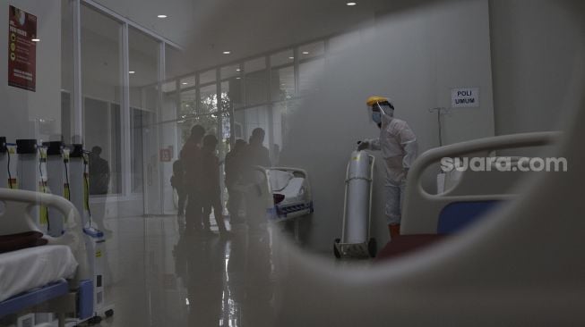 Petugas menyiapkan kamar yang akan digunakan sebagai ruang perawatan di Tower 8 Rumah Sakit Darurat COVID-19 (RSDC), Pademangan, Jakarta, Selasa (15/6/2021). [Suara.com/Angga Budhiyanto]