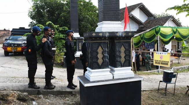 Personel Korps Brimob dari Mabes Polri melakukan pengamanan wilayah di Desa Bantengan, Wungu, Kabupaten Madiun, Jawa Timur, Selasa (15/6/2021).  ANTARA FOTO/Siswowidodo