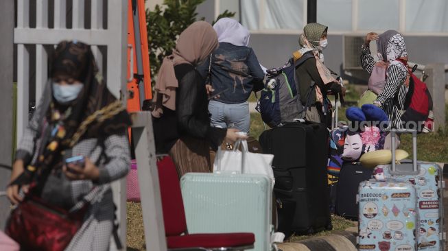 Sejumlah Pekerja Migran Indonesia (PMI) berjalan meninggalkan ruangan usai menjalani isolasi di Rumah Sakit Darurat COVID-19 (RSDC) Wisma Atlet Pademangan, Jakarta, Selasa (15/6/2021). [Suara.com/Angga Budhiyanto]