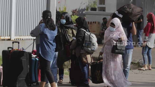 Sejumlah Pekerja Migran Indonesia (PMI) berjalan meninggalkan ruangan usai menjalani isolasi di Rumah Sakit Darurat COVID-19 (RSDC) Wisma Atlet Pademangan, Jakarta, Selasa (15/6/2021). [Suara.com/Angga Budhiyanto]