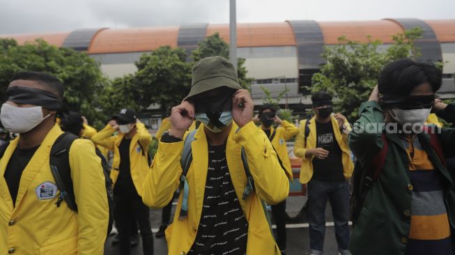 Sejumlah massa yang tergabung dalam Badan Eksekutif Mahasiswa Seluruh Indonesia (BEM SI) mengenakan kain penutup mata saat melakukan aksi unjuk rasa di sekitar Gedung Komisi Pemberantasan Korupsi (KPK), Jakarta, Rabu (16/6/2021). [Suara.com/Angga Budhiyanto]