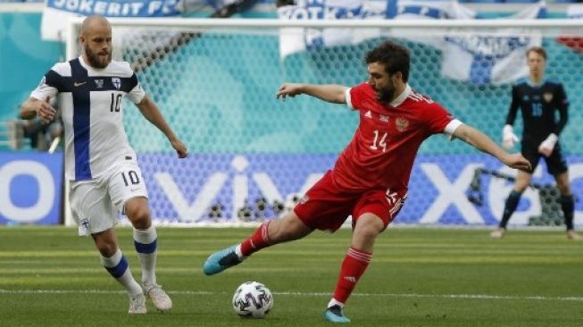 Penyerang Finlandia Teemu Pukki berebut bola dengan pemain Rusia dalam pertandingan Grup B Euro 2020 yang digelar di St.Petersburg Stadium, Rabu (16/6/2021). [AFP]