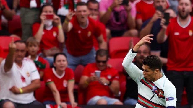 Penyerang Timnas Portugal, Cristiano Ronaldo merayakan gol ke gawang Hungaria dalam laga perdana mereka di Grup F Euro 2020 yang berlangsung di Puskas Arena, Budapest, Selasa (15/6/2021). [Alex Pantling / POOL / AFP].