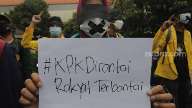 Massa yang tergabung dalam Badan Eksekutif Mahasiswa Seluruh Indonesia (BEM SI) membawa kertas bertuliskan '#KPK Dirantai Rakyat Terbantai' saat melakukan aksi unjuk rasa di sekitar Gedung Komisi Pemberantasan Korupsi (KPK), Jakarta, Rabu (16/6/2021). [Suara.com/Angga Budhiyanto]