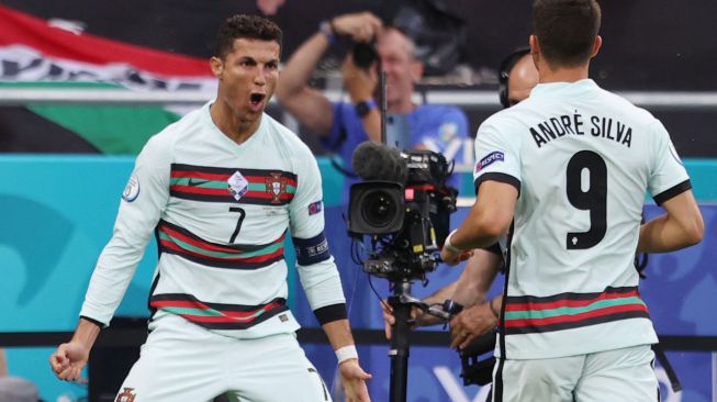 Pemain depan Portugal Cristiano Ronaldo merayakan setelah mencetak gol kedua mereka selama pertandingan sepak bola Grup F EURO 2020 antara Hungaria melawan Portugal di Puskas Arena di Budapest ,Rabu (16/6/2021) dini hari WIB. [Foto/AFP]