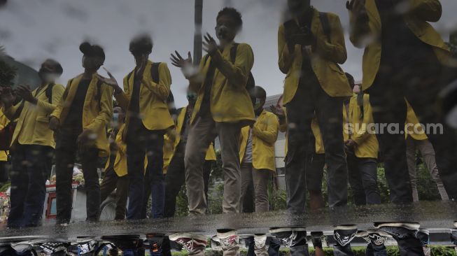 Refleksi sejumlah massa yang tergabung dalam Badan Eksekutif Mahasiswa Seluruh Indonesia (BEM SI) melakukan aksi unjuk rasa di sekitar Gedung Komisi Pemberantasan Korupsi (KPK), Jakarta, Rabu (16/6/2021). [Suara.com/Angga Budhiyanto]