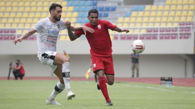 Striker Persis Solo, Beto Goncalves (kanan) berebut bola dengan bek Bali United, William Pacheco dalam uji coba bertajuk 'Tour de Java' di Stadion Manahan, Rabu (16/6/2021) sore. [Dok Media Persis Solo]