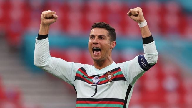 Penyerang Portugal Cristiano Ronaldo melakukan selebrasi selama pertandingan sepak bola Grup F EURO 2020 antara Hungaria melawan Portugal di Puskas Arena di Budapest , Rabu (16/6/2021) dini hari WIB. Alex Pantling / POOL / AFP