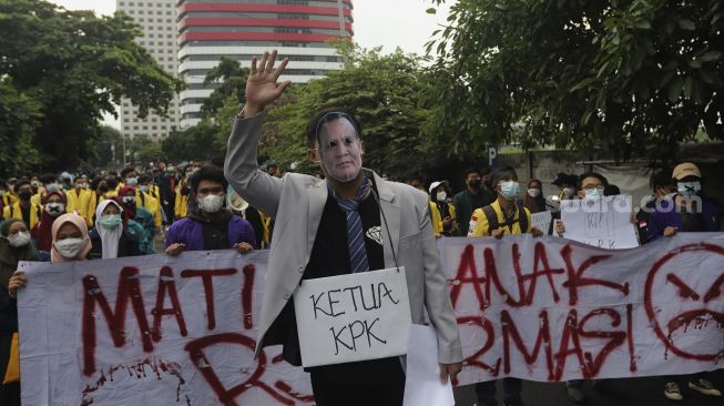 Massa yang tergabung dalam Badan Eksekutif Mahasiswa Seluruh Indonesia (BEM SI) mengenakan topeng Ketua KPK Firli Bahuri saat melakukan aksi unjuk rasa di sekitar Gedung Komisi Pemberantasan Korupsi (KPK), Jakarta, Rabu (16/6/2021). [Suara.com/Angga Budhiyanto]