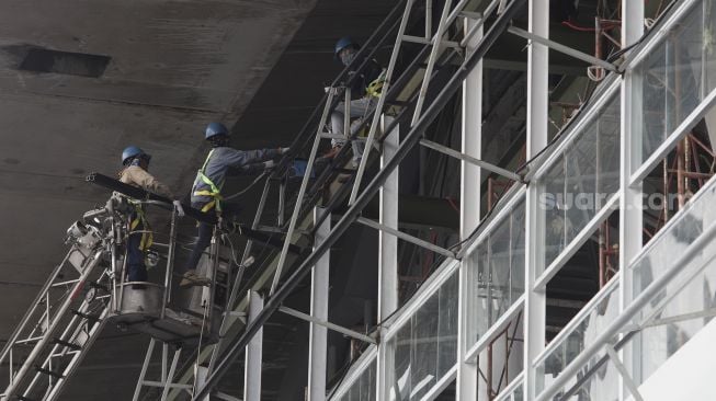 Pekerja menyelesaikan pembangunan halte Centrale Stichting Wederopbouw (CSW) di kawasan Kebayoran Baru, Jakarta, Kamis (17/6/2021). [Suara.com/Angga Budhiyanto]